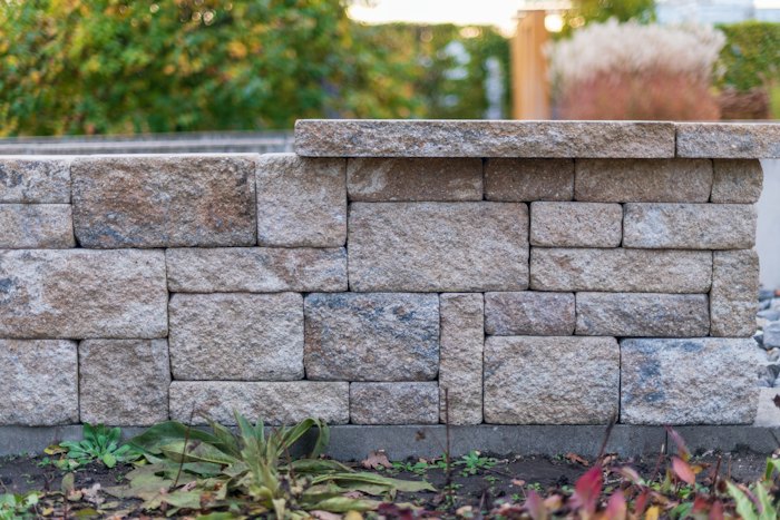 Stone retaining wall with plants in front
