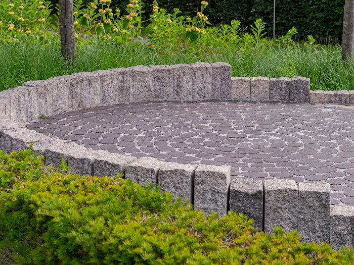 Circular paver patio with a low stone wall