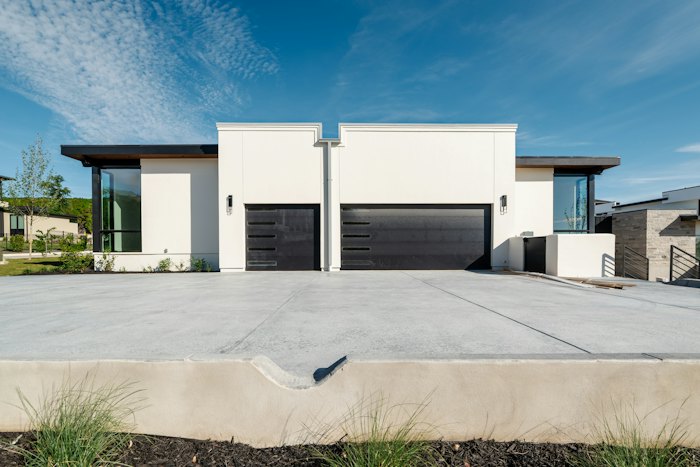 Contemporary white homes with clean concrete driveways