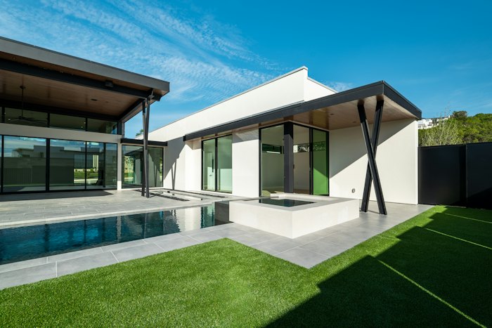 Modern home with pool and green lawn